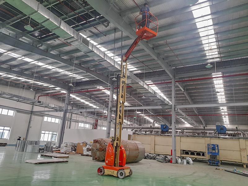 công nhân lái xe nâng người Toucan làm việc trong nhà máy