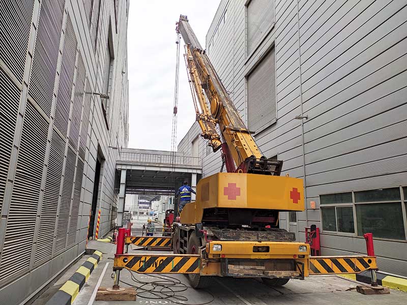 xe cẩu bánh lốp thực hiện cẩu máy công nghiệp lên tầng 2