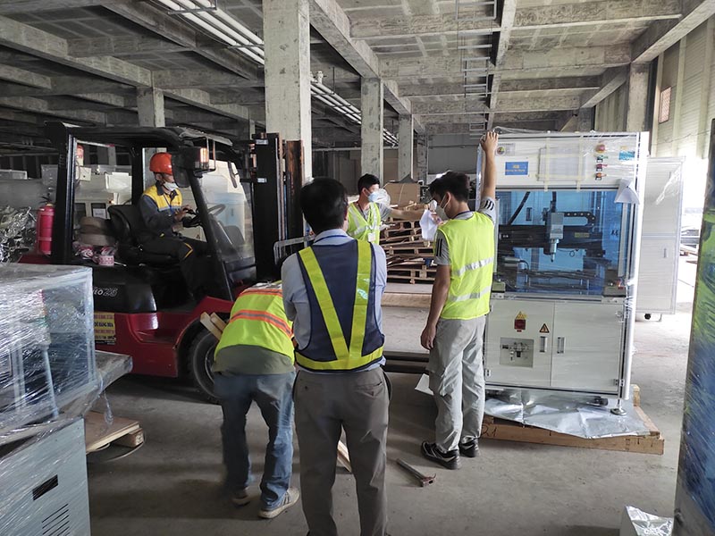công nhân lái xe nâng hàng di chuyển máy công nghiệp vào vị trí