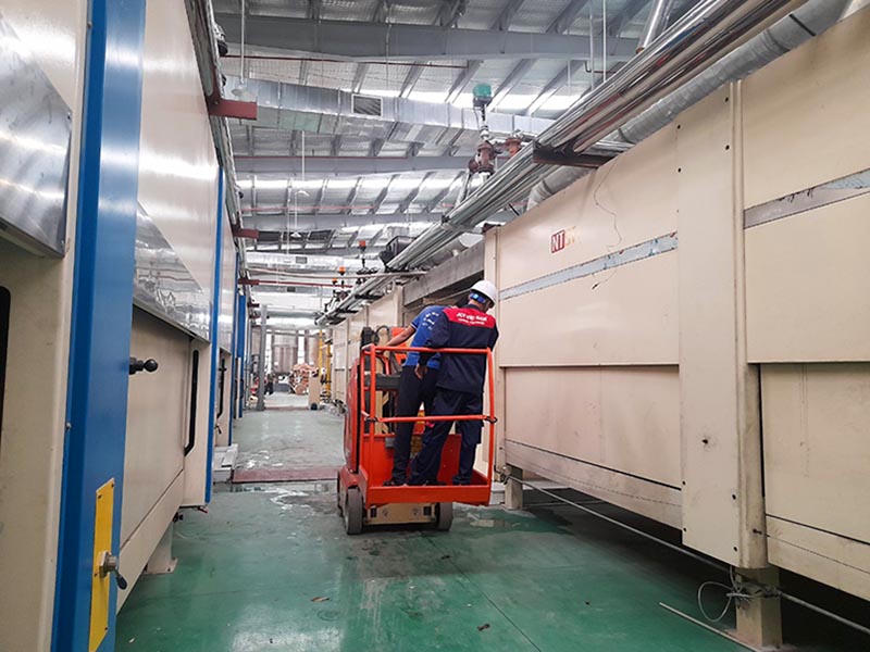 Công nhân lái xe nâng người 10m di chuyển trong nhà máy