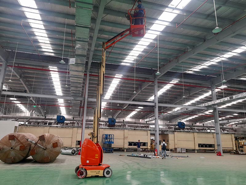 xe nâng người 10m đang làm việc trong nhà máy