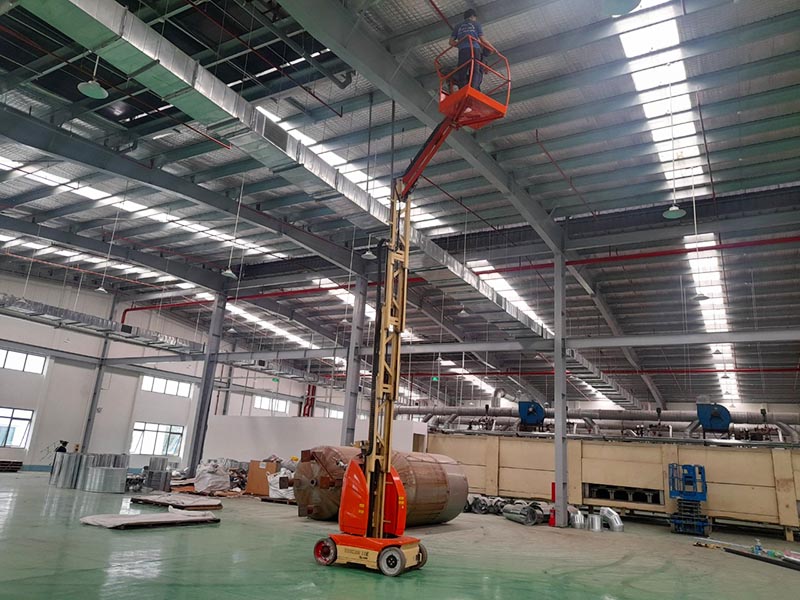 công nhân vận hành xe nâng người lên thằng JLG Toucan T10E làm việc trong nhà máy