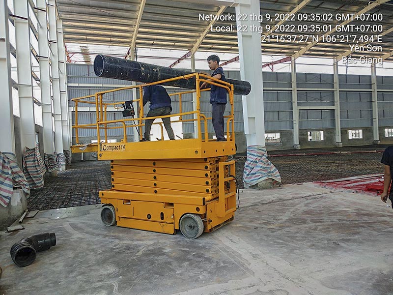 công nhân vận hành xe nâng người cắt kéo 14m làm việc