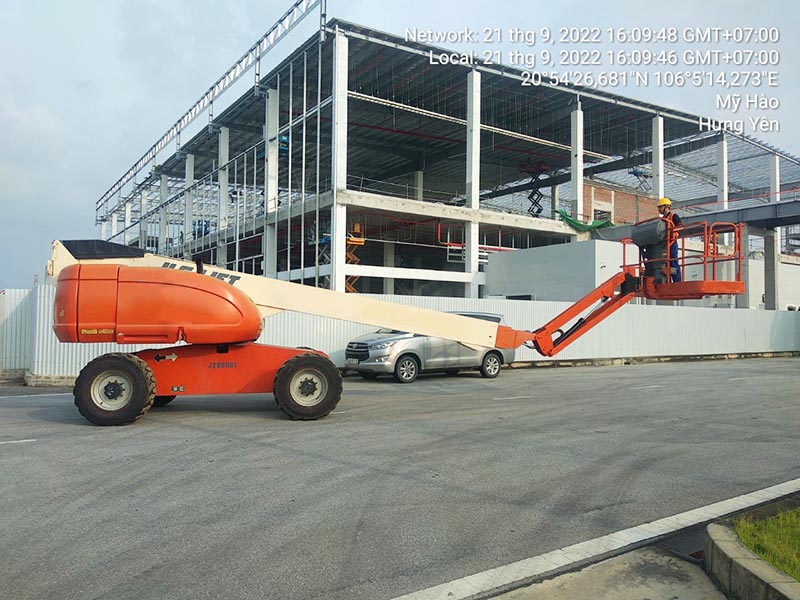 công nhân vận hành xe boomlift cần thẳng tại công trường