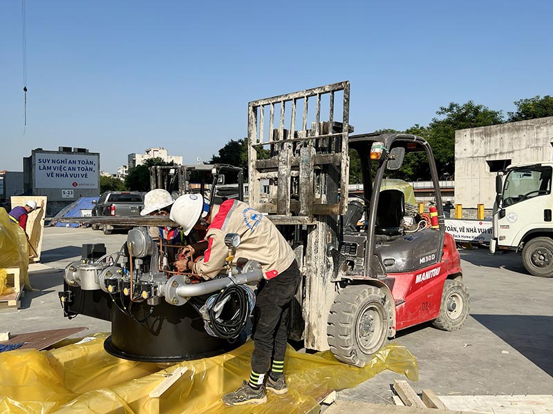 công nhân sử dụng xe nâng hàng tháo thùng gỗ di chuyển thiết bị
