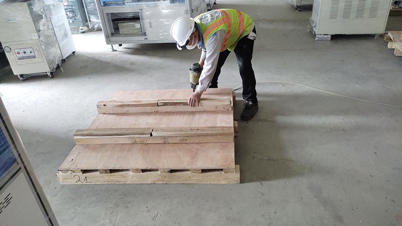 công nhân đóng khung đỡ hàng hoá trên pallet gỗ