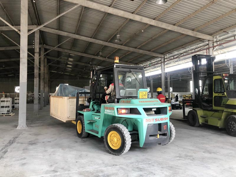 xe nâng hàng di chuyển thùng hàng vào vị trí