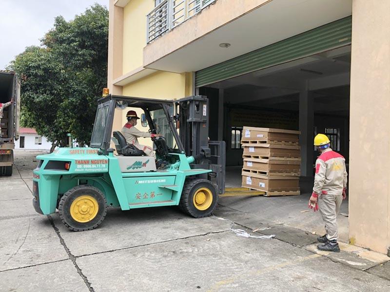 xe nâng hàng di chuyển pallet gỗ trong nhà máy