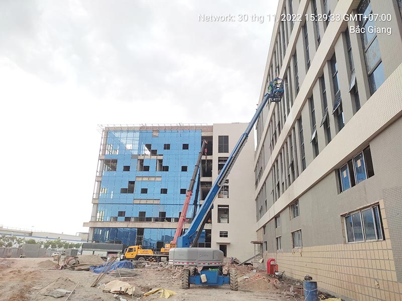 xe cẩu bánh lốp và xe nâng người boomlift làm việc tại công trường xây dựng