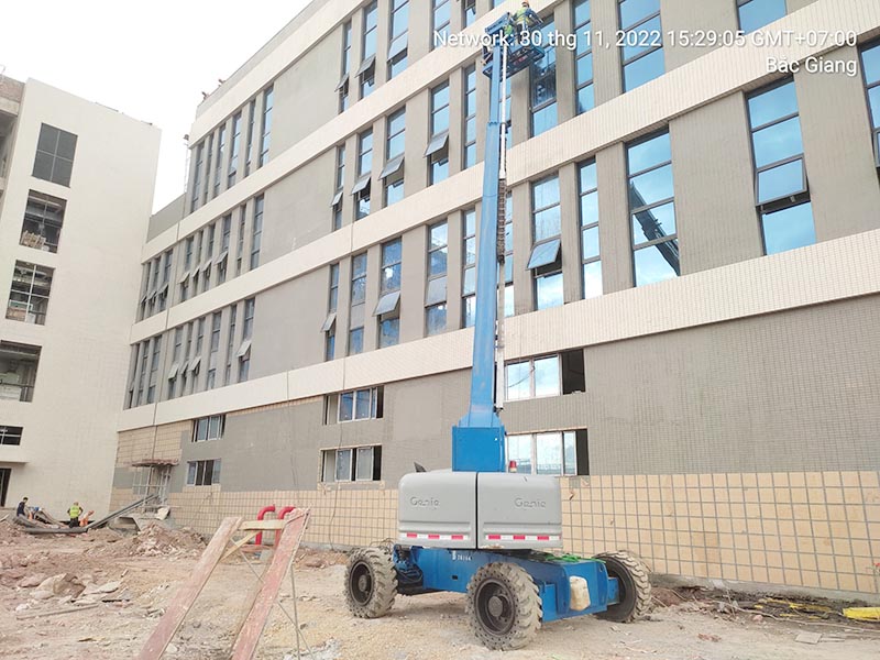 công nhân vận hành xe nâng người cần thẳng làm việc tại công trường