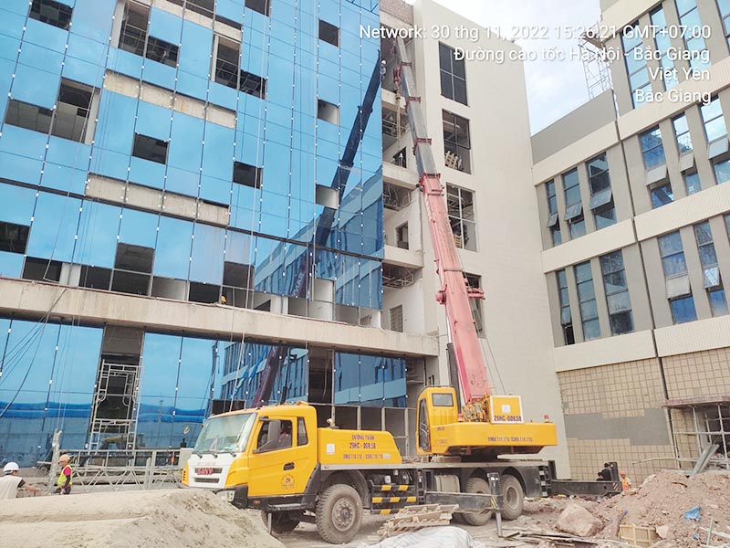 xe cẩu bánh lốp cẩu vật liệu xây dựng lên tầng 5 của toà nhà