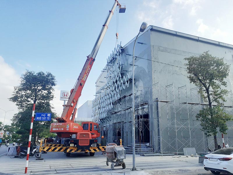 xe cẩu lốp nâng cấu kiện trang trí toà nhà