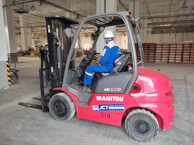 công nhân lái xe nâng hàng 2,5 tấn trong nhà kho nhà xưởng