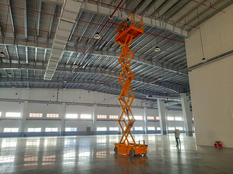 công nhân vận hành xe nâng người cắt kéo lắp đặt đường ống pccc