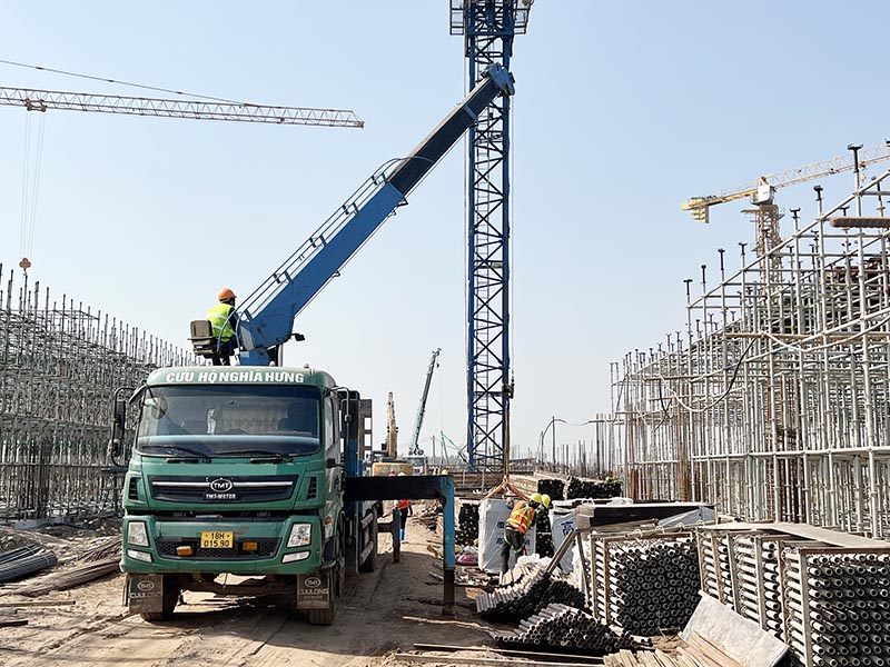 Công nhân vận hành xe cẩu tự hành nâng vận chuyển giáo xây dựng