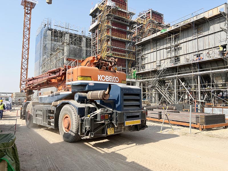xe cẩu bánh lốp KOBELCO làm việc tại công trường xây dựng