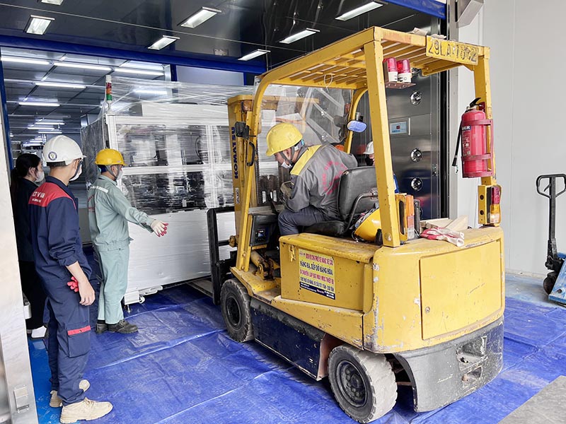 công nhân sử dụng xe nâng hàng 3 tấn di chuyển thiết bị trong nhà máy