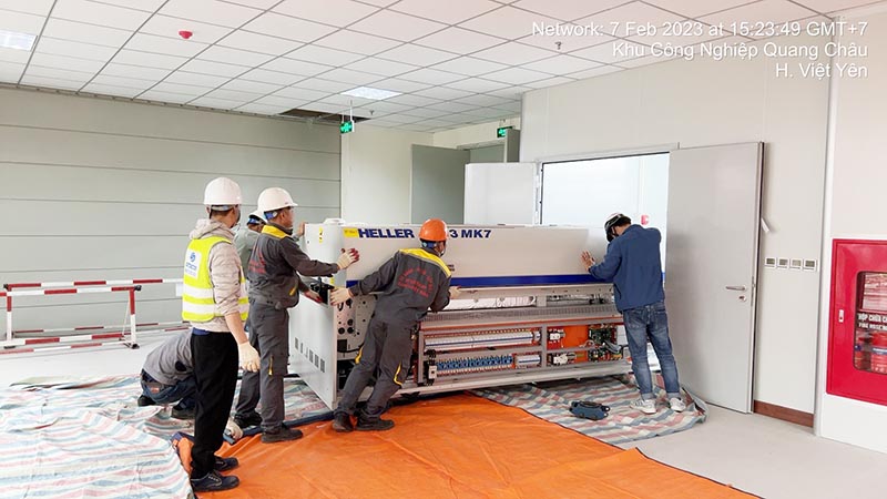 công nhân di chuyển máy công nghiệp vào vị trí tập kết trong nhà máy