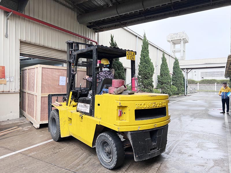 công nhân lái xe nâng hàng komatsu di chuyển kiện hàng vào nhà máy