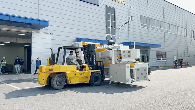 công nhân lái xe nâng hàng di chuyển máy công nghiệp hạng nặng
