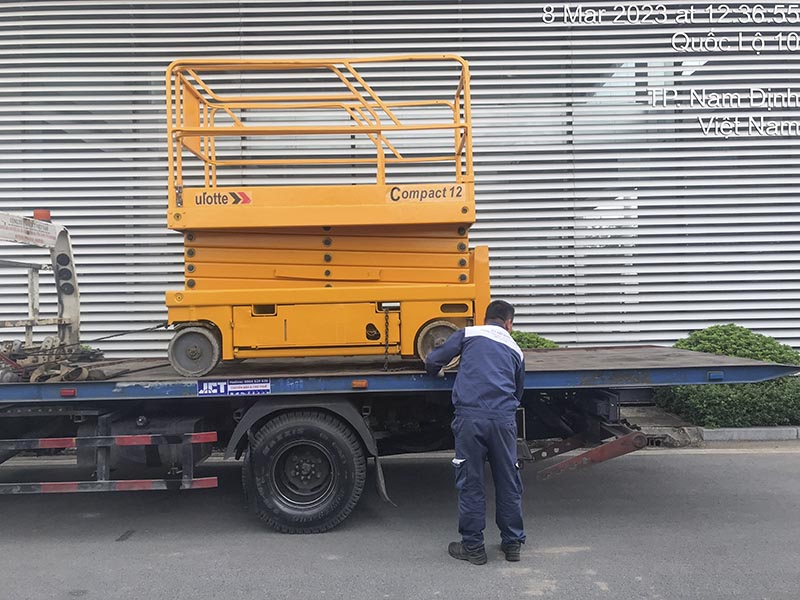 vận chuyển xe nâng người cắt kéo 12m bằng xe vận tải trượt sàn