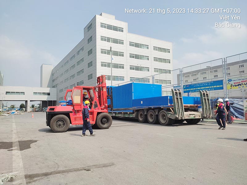 công nhân sử dụng xe nâng hàng để nâng hạ, di chuyển hàng hoá có kích thước lớn