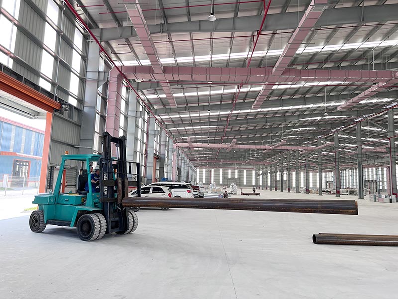 công nhân lái xe nâng hàng di chuyển sắt thép