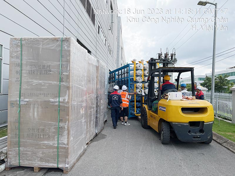 công nhân lái xe nâng hàng di chuyển thiết bị trong nhà máy