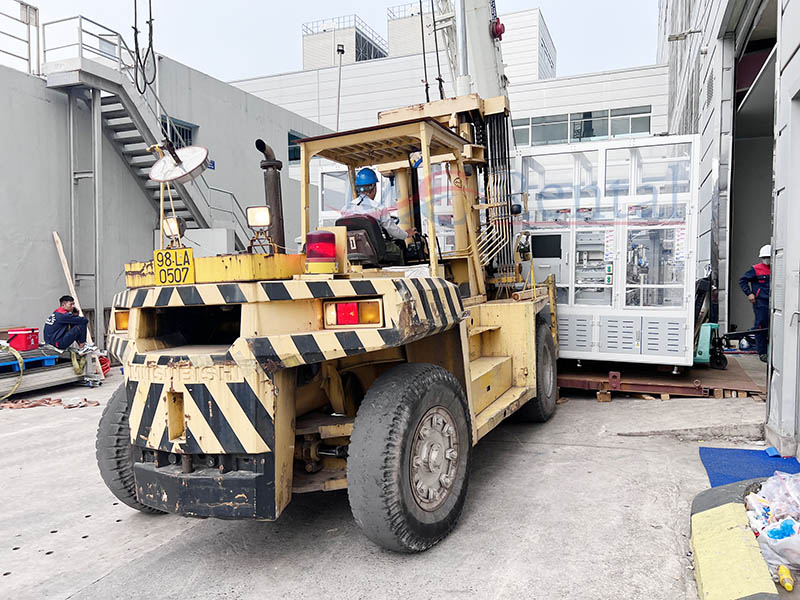 xe nâng hàng di chuyển máy công nghiệp đến vị trí cẩu