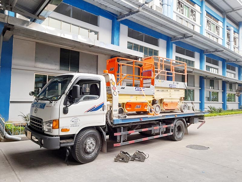 vận chuyển xe nâng người cắt kéo bằng xe trượt sàn