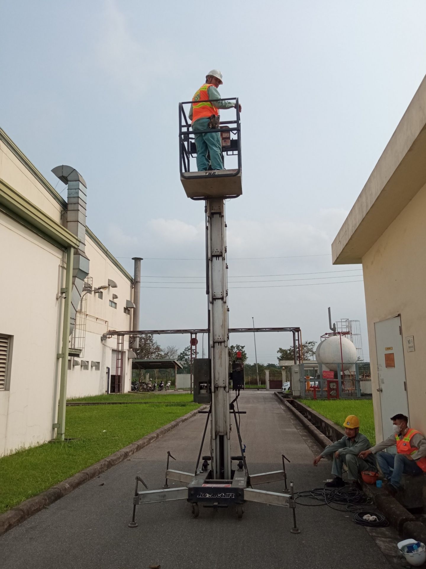công nhân lái xe nâng người lên thẳng (vertical lift)