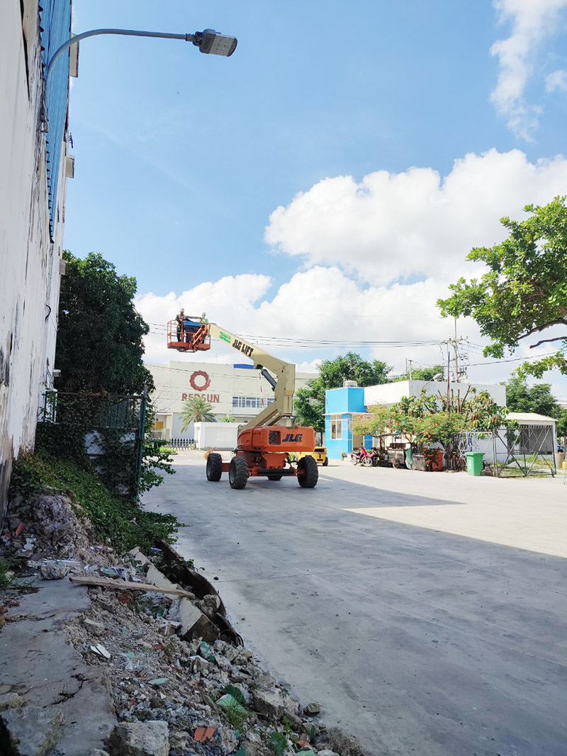xe nâng người boomlift làm việc bên ngoài nhà máy