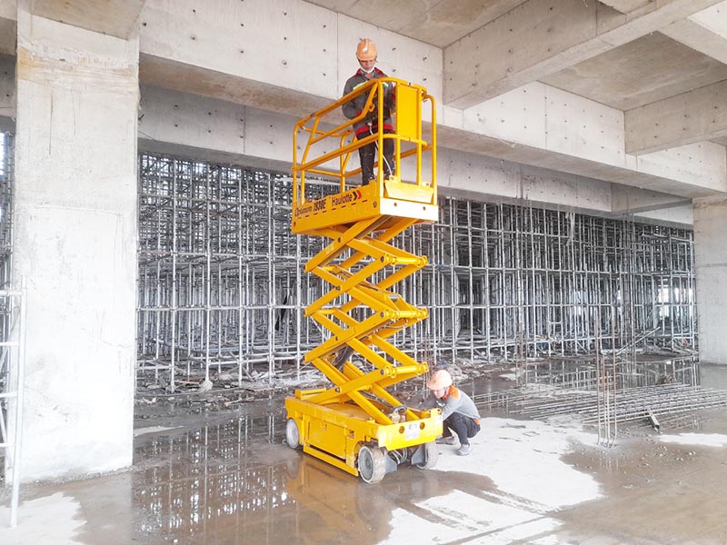 công nhân điều khiển xe nâng người cắt kéo 8m làm việc
