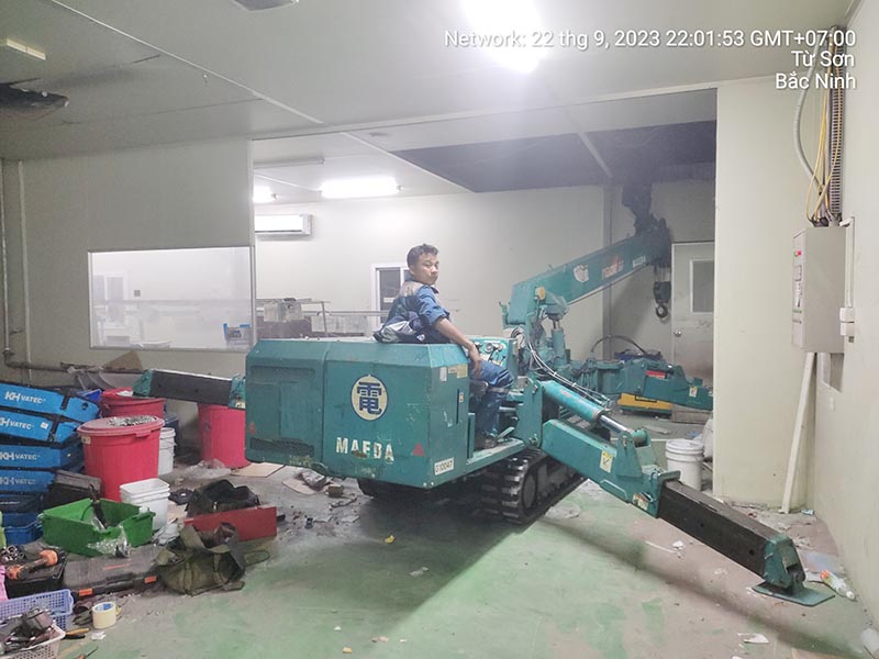 công nhân vận hành xe cẩu chân nhện trong toà nhà
