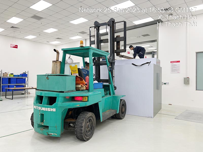 công nhân lái xe nâng hàng di chuyển máy công nghiệp