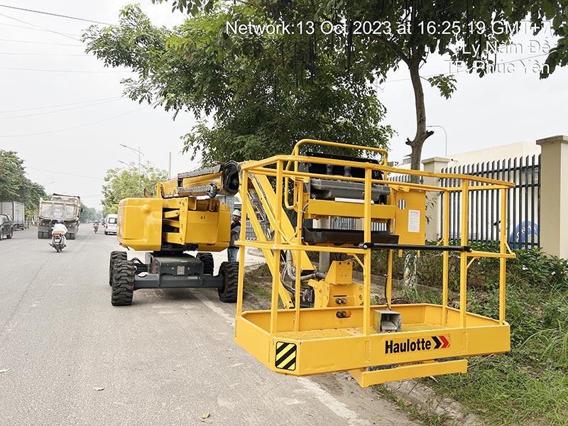 công nhân điều khiển xe nâng người boomlift tại thân xe
