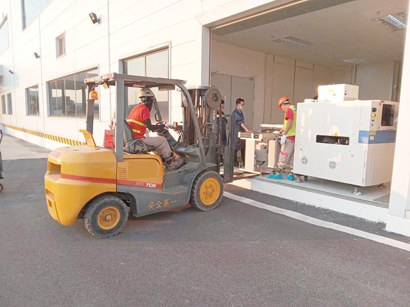 công nhân vận hành xe nâng hàng TCM di chuyển thiết bị công nghiệp