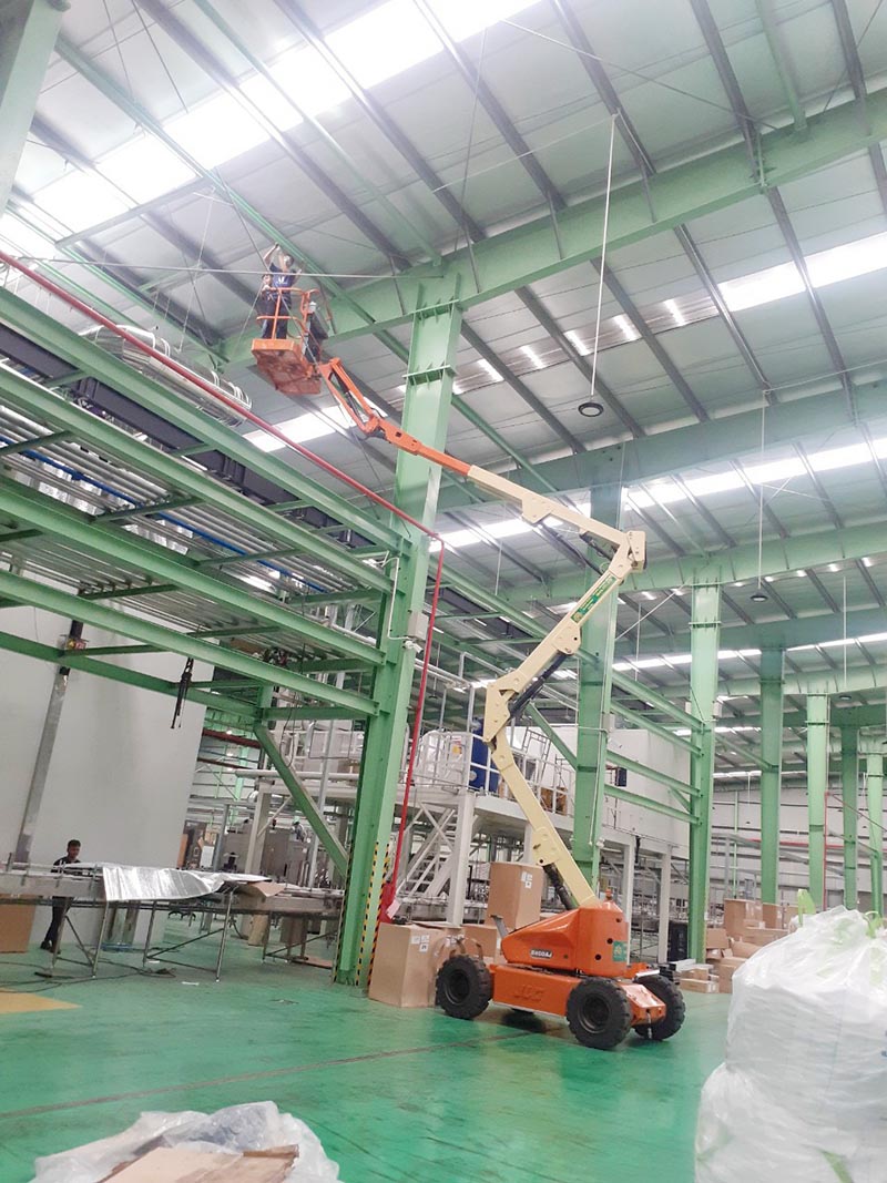 công nhân lái xe nâng người boomlift 16 mét làm việc trong nhà máy
