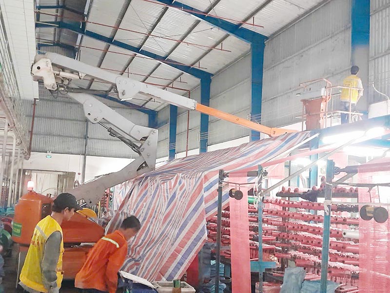 xe nâng người boomlift làm việc trong nhà máy